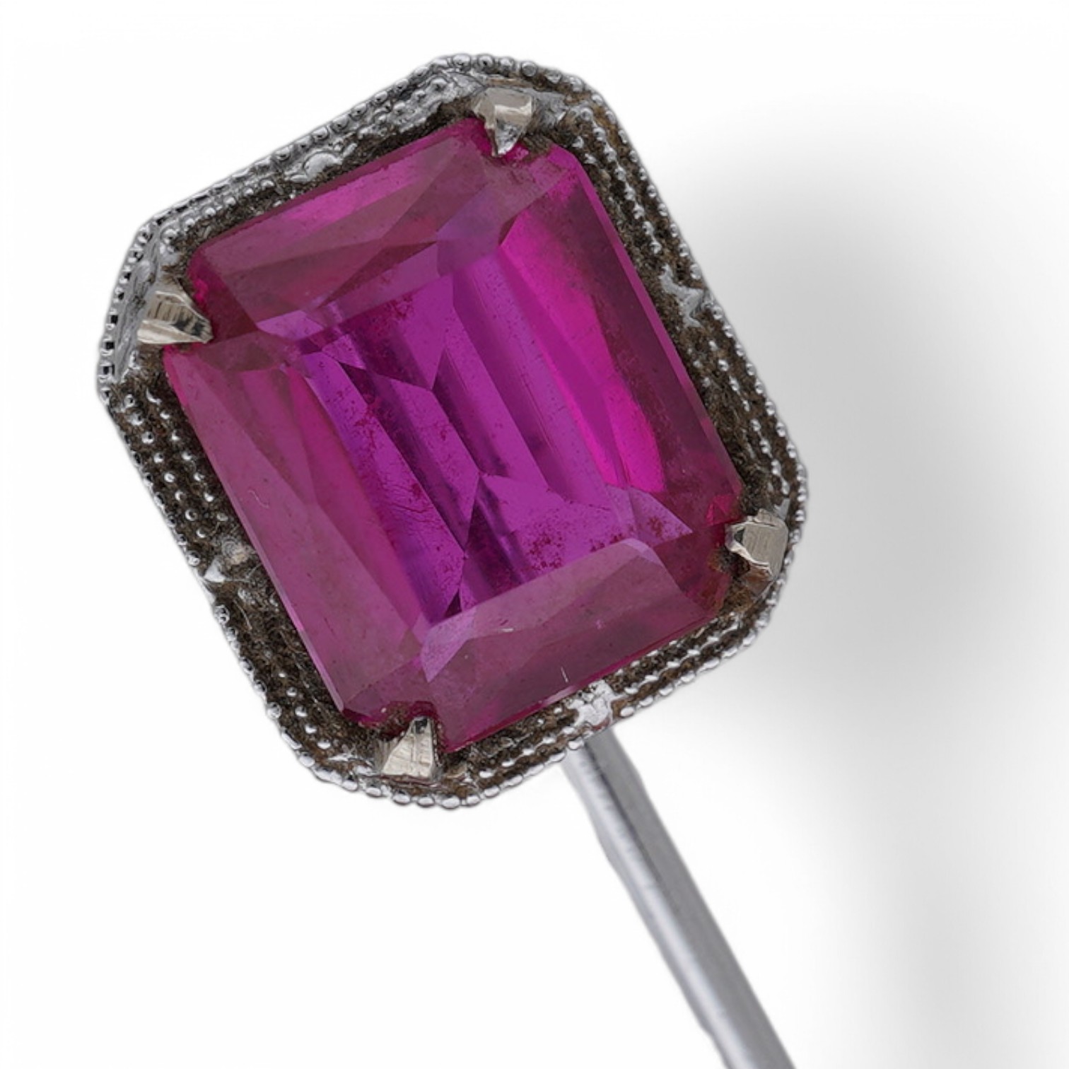 A North American? 10k white metal and single stone emerald cut synthetic ruby set stick pin, 55mm, gross weight 1.1 grams. Condition - fair to good